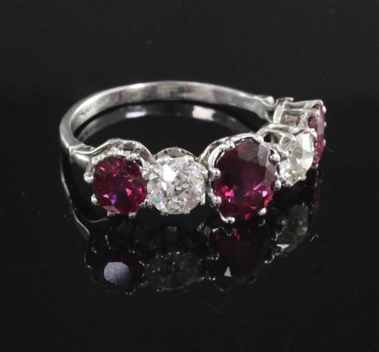 A platinum, three stone natural ruby and two stone diamond half hoop ring, size R.